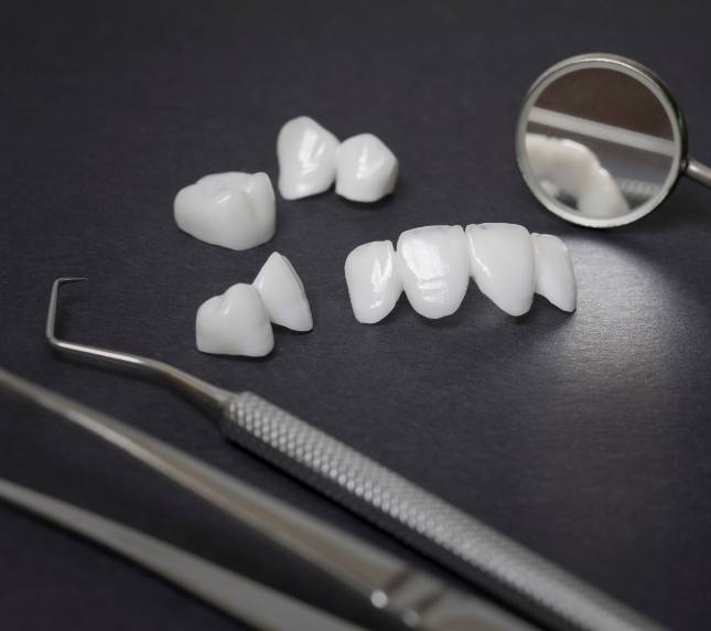 Dental restorations sitting next to dental instruments