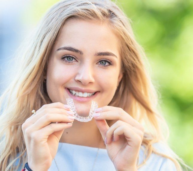 Woman putting in an Invisalign aligner