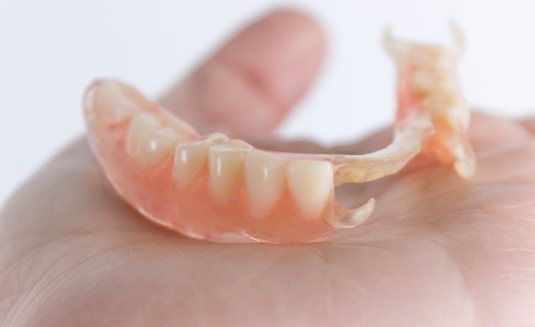 Partial dentures lying on palm of hand