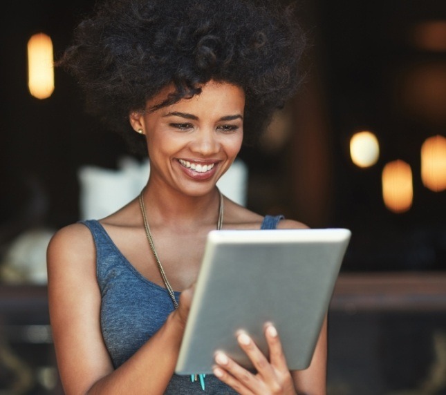 Woman smiling and looking at a tablet