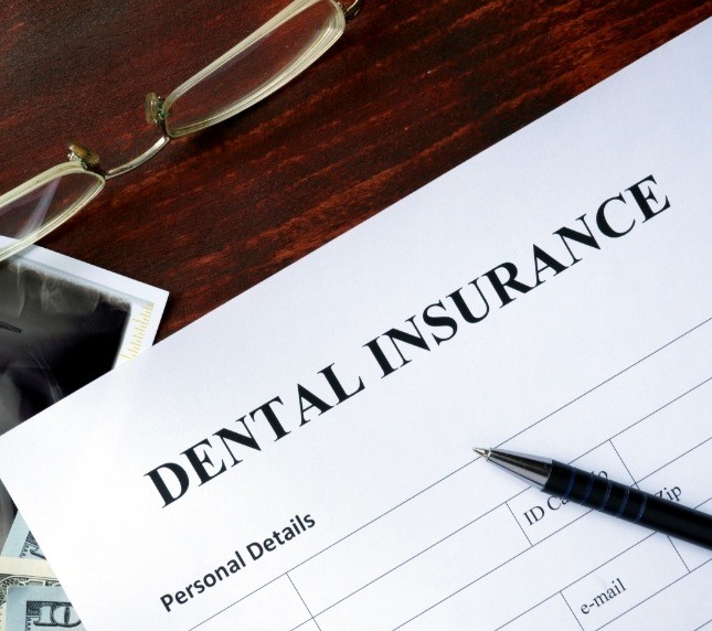 Dental insurance form lying on a wooden desk