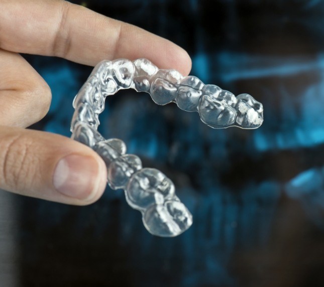 Holding an Invisalign aligner between fingers