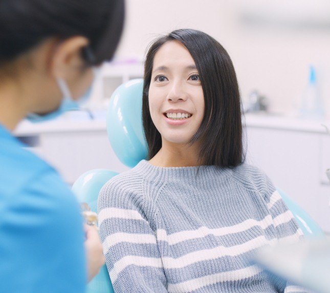 Female dental patient talking to dentist