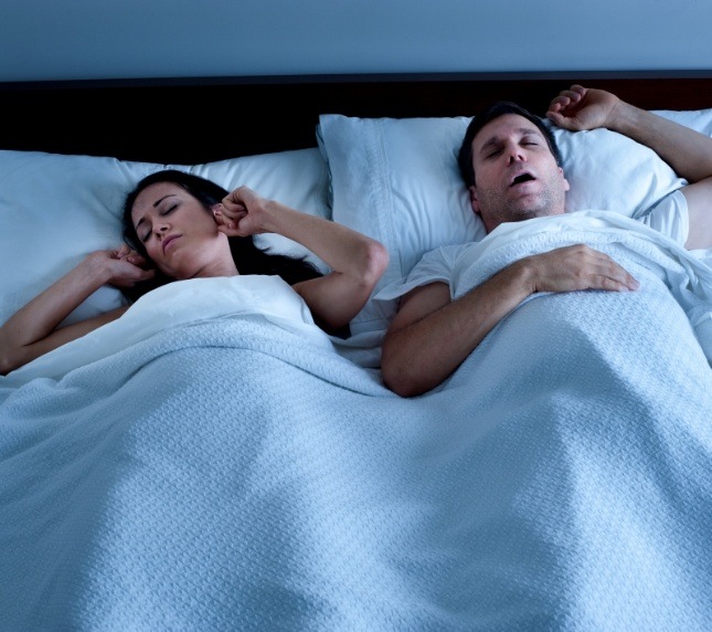 Man and woman in bed with man snoring