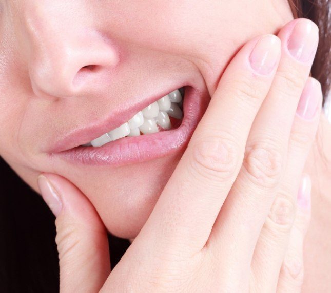 Woman with tooth pain needing tooth extraction in Owings Mills